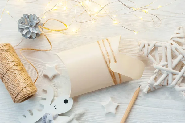 Mockup kerst Kraft geschenkdozen met tag op houten achtergrond. Top View voor wenskaart — Stockfoto