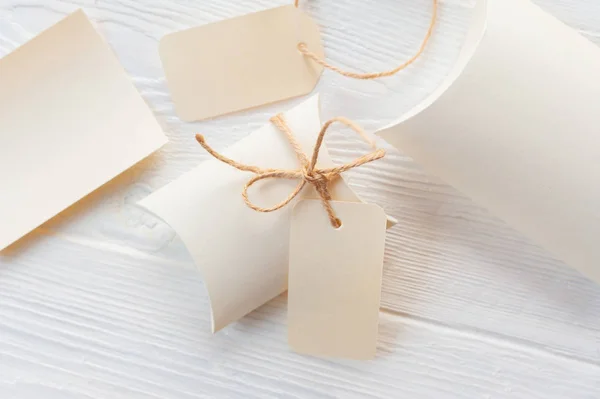 Confezioni regalo kraft di Natale mockup con tag su sfondo in legno. Vista dall'alto per biglietto di auguri — Foto Stock