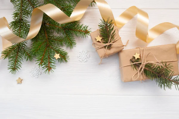 Burla árbol blanco de Navidad, arco beige, caja de regalo de oro y cono. Piso sobre un fondo de madera blanca, con lugar para su texto. Vista superior — Foto de Stock