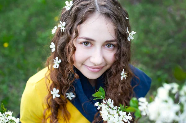 Feliz joven mujer disfrutando del olor flores sobre fondo de jardín de primavera —  Fotos de Stock