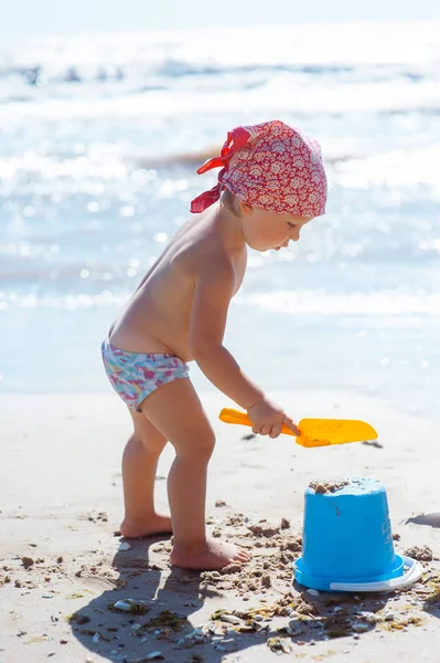 아이 소녀는 해변에서 재생합니다. 해변에 어린이 건물 모래 성입니다. 가족을위한 여름 물 재미. 바다 해안에서 장난감 양동이와 스페이드소녀 — 스톡 사진