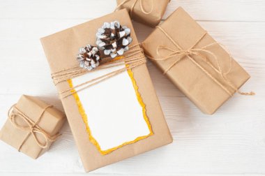 Metin için yer ile kağıt tebrik kartı levha için Noel arka plan. Ahşap arka planda hediye kutusu. Düz yatıyordu, üst görünüm fotoğraf mockup