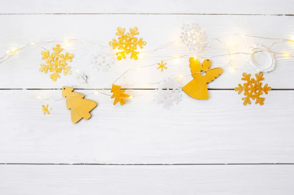 Kerst achtergrond voor wenskaart met plaats voor tekst. x-mas gouden speelgoed en lint op houten achtergrond. Platte lay, bovenaanzicht fotomodel — Stockfoto