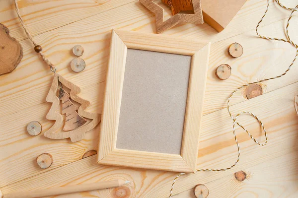 Marco de madera ligero de Navidad para la foto sobre un fondo de madera con cuerda y juguetes de madera. Flat lay, maqueta de fotos vista superior — Foto de Stock