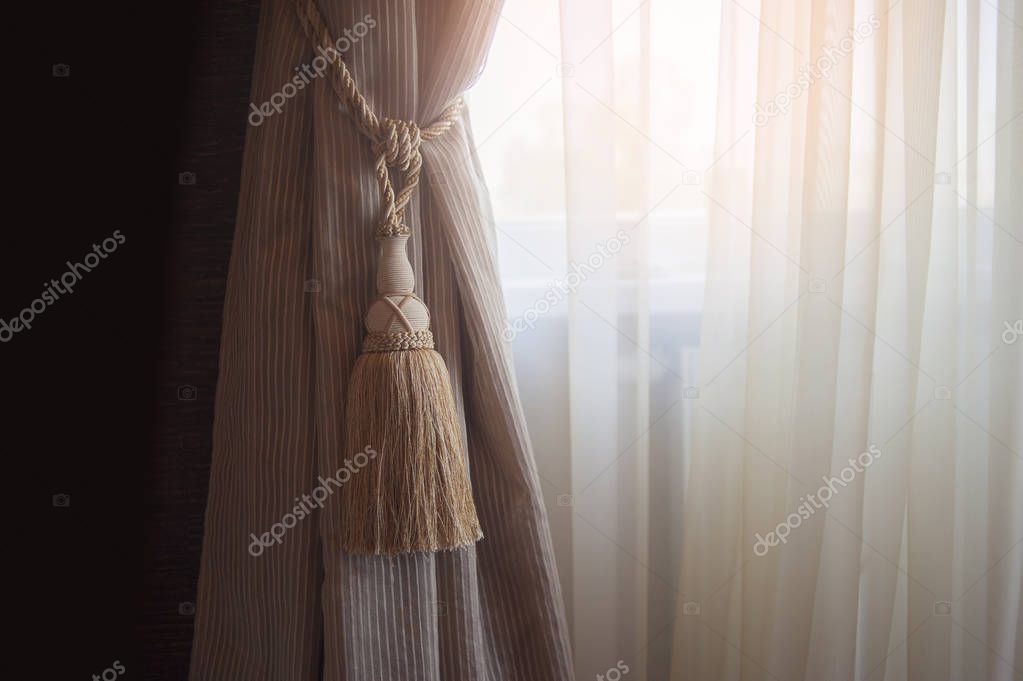 Decoration of the interior of the living room in the classical, palace style. Curtains of dense fabric with ornaments, lambrequin, pelmet, jabot, and tulle with embroidery