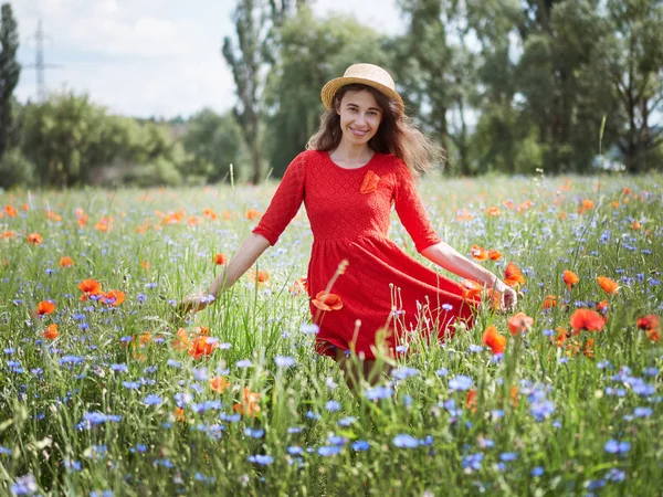 Прекрасная молодая романтичная женщина в соломенной шляпе на маковом цветочном поле позирует на заднем плане летом. В соломенной шляпе. Мягкие цвета — стоковое фото