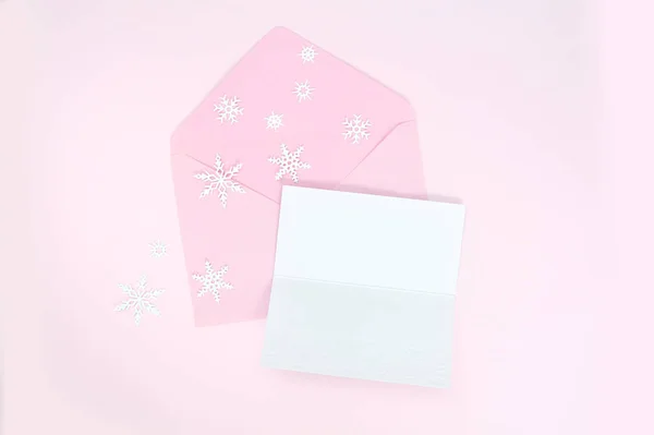 Envelope rosa aberto com flocos de neve de Natal e folha de papel em branco para o seu texto para cartão de saudação — Fotografia de Stock