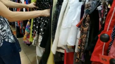 Kiev, Ukrayna - 23 Mayıs 2019: Giyim mağazası soyunma odası. Beyaz genç kadın evde veya mağazada dolapta onu moda kıyafeti giysileri seçerek