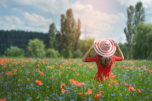 Belle jeune femme romantique en chapeau de paille sur champ de fleurs de pavot posant sur fond d'été. Elle porte un chapeau de paille. Couleurs douces — Photo