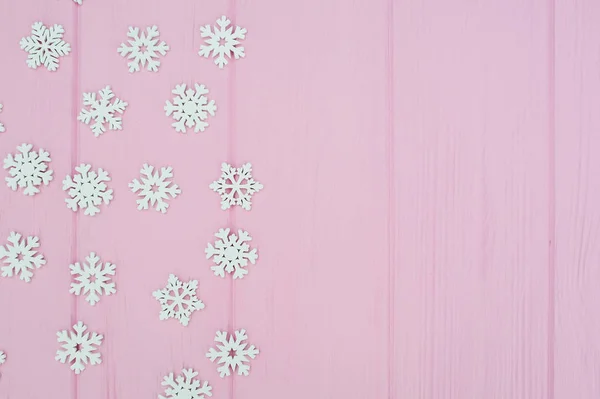 Metin için yer ile pembe ahşap arka plan üzerinde beyaz noel kar taneleri dekorasyon. xmas duvar kağıdı. düz döşeme, üst görünüm — Stok fotoğraf