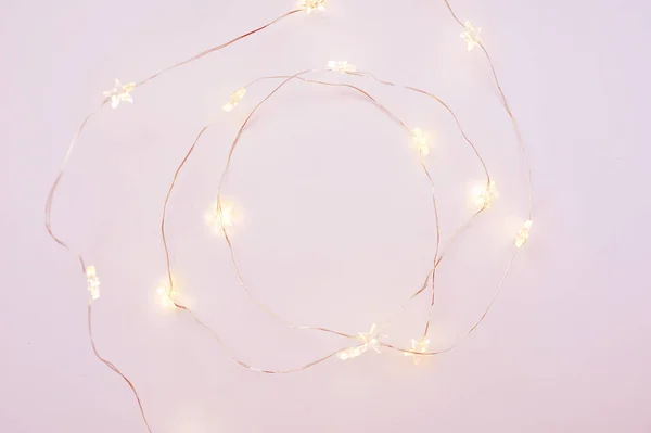 Рождественские огни гирлянды круговой границы на розовом фоне с местом для вашего текста. Квартира, копировальное пространство — стоковое фото