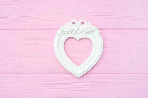 Gypsum vintage photo frame in the shape of a heart on a pink wooden background with place for text. Perfect for greeting card, invitation, valentine day, wedding — Stock Photo, Image