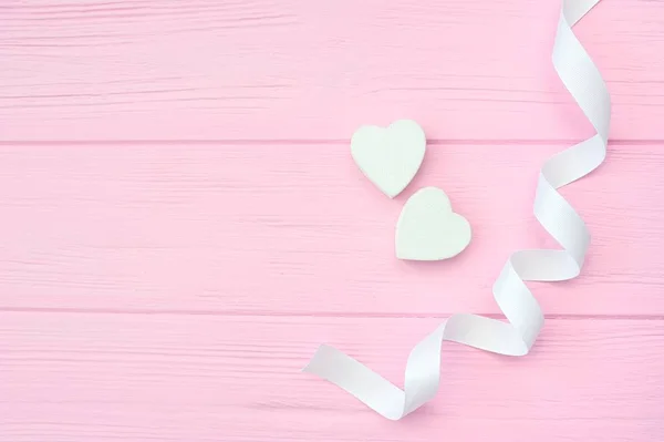 Dos corazones blancos y cinta sobre fondo de madera rosa con lugar para su texto de amor. Asiento plano, vista superior. Diseño del Día de San Valentín — Foto de Stock