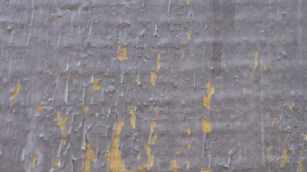 Jede Menge Risse verblasster grauer Farbe auf der Holzoberfläche. Zerstörte Hausfassade und abblätternde Farbe. Altes verlassenes Haus mit weißer Farbe, das wegfällt. Hohe Qualität — Stockvideo