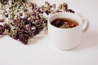 Bardak bitkisel çay ve hafif bir arka plan üzerinde otlar. Kopya alanı