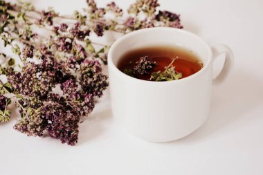 Bardak bitkisel çay ve hafif bir arka plan üzerinde otlar. Kopya alanı