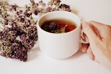 El ve hafif bir arka plan üzerinde otlar bitkisel çay