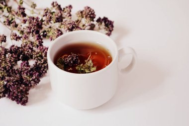 Bardak bitkisel çay ve hafif bir arka plan üzerinde otlar. Kopya alanı