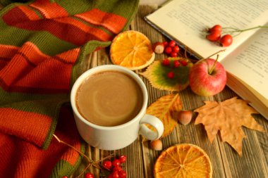 Sonbahar kompozisyon kahve Kupası, kitap, renkli atkı, yaprakları, elma, kurutulmuş portakal ahşap arka plan sonbahar kavram rahat bir ev üzerinde