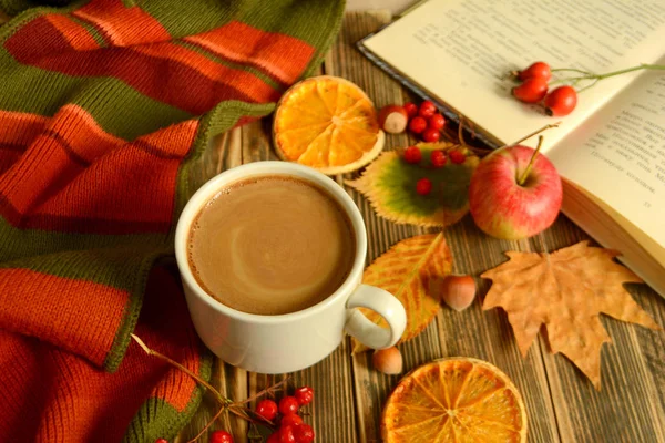 Sonbahar kompozisyon kahve Kupası, kitap, renkli atkı, yaprakları, elma, kurutulmuş portakal ahşap arka plan sonbahar kavram rahat bir ev üzerinde