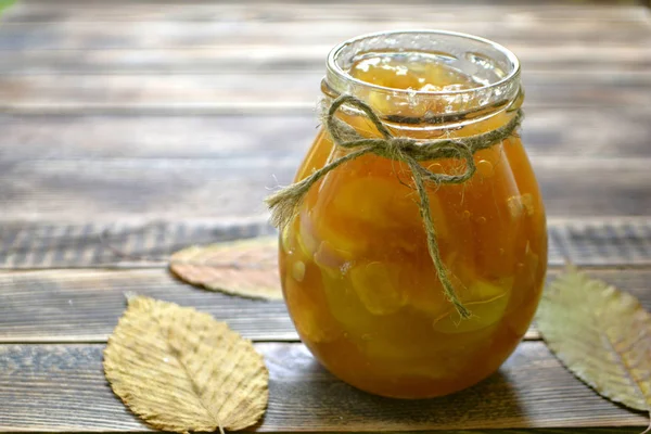 Apple jam in a jar on a wooden background