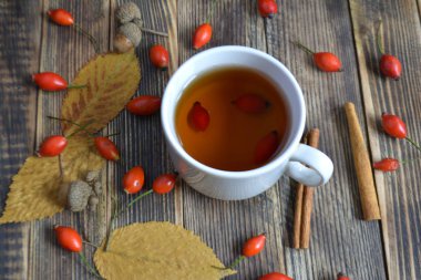 Sonbahar kompozisyon rose hips fındıklı çay yaprakları. Bir fincan çay rose hips ile. Sonbahar sıcak içecek