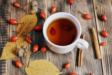 Sonbahar kompozisyon rose hips fındıklı çay yaprakları. Bir fincan çay rose hips ile. Sonbahar sıcak içecek