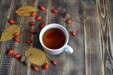 Sonbahar kompozisyon rose hips fındıklı çay yaprakları. Bir fincan çay rose hips ile. Sonbahar sıcak içecek