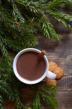 Kahve süt, sıcak çikolata veya kakao bir fincan ve köknar dallarında tarçın çubuğu ile. Kış soğuk hava için sıcak bir içecek. Yeni yıl ve Noel kavramı