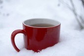 Červený hrnek s čajem na sněhu zimní ráno Copy prostor
