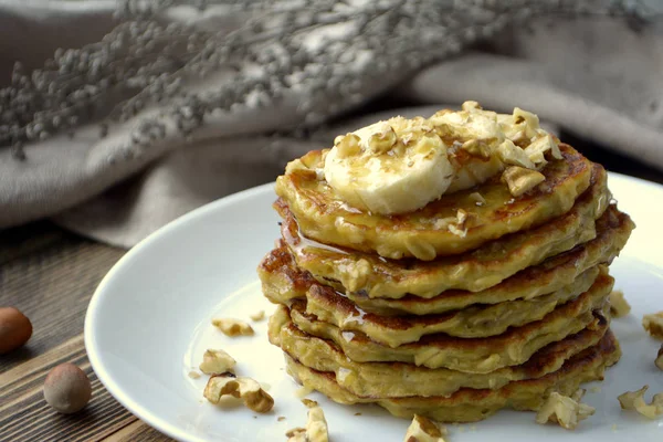 Stack of oatmeal pancake with banana, nuts and honey Healthy Breakfast