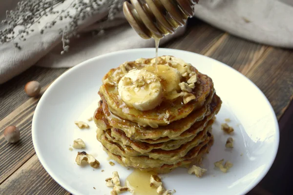 Stack of oatmeal pancake with banana, nuts and honey Healthy Breakfast