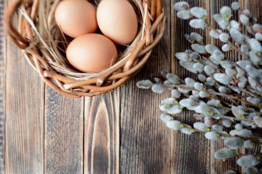 Sepet ve willow ahşap tablo Easter kavramı üzerinde yumurta