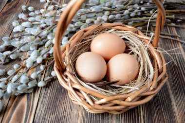 Sepet ve willow ahşap tablo Easter kavramı üzerinde yumurta