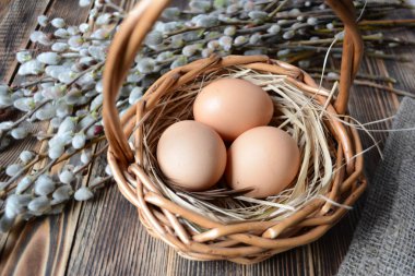 Sepet ve willow ahşap tablo Easter kavramı üzerinde yumurta