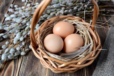 Sepet ve willow ahşap tablo Easter kavramı üzerinde yumurta