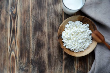 Tahta bir kapta süzme peynir, bardakta süt. Çiftlik ürünleri. Köy Kahvaltısı