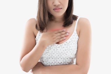A woman suffering from heartburn on a gray background. clipart