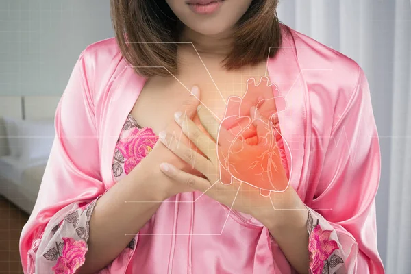 彼女の胸が痛み夜ピンクのサテンのナイトウェアでアジアの女性 急性の痛み可能な心臓発作 心臓病や心痛 — ストック写真
