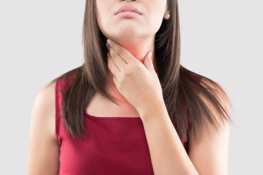 Asian woman with a sore throat or thyroid gland against the gray background. Acid reflux or Heartburn, Neck pain, People body problem concept clipart