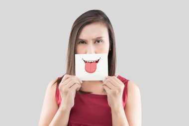 Şirin dil yüzü olan bir kağıt üzerine ağzını önünde tutan Asyalı kadın