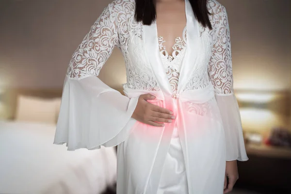Женщина в белой шелковой ночнушке и кружевном халате с желудком — стоковое фото
