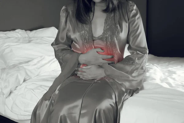 Женщина Атласной Ночной Рубашке Страдающая Боли Животе Сидя Ночью Постели — стоковое фото