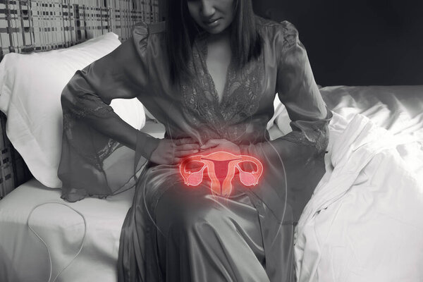 Women in silk nightgown have uterine pain at night. Have a stomach ache because implantation cramping. illustration of the uterus is on the human body.
