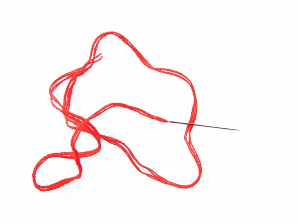 Um fio escarlate vermelho brilhante com uma agulha de costura é um objeto isolado em um fundo branco . — Fotografia de Stock