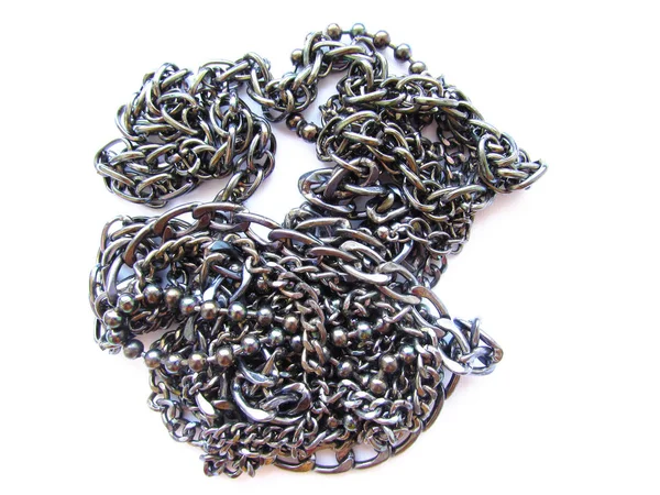 Koraliki z ciemnych łańcuchów metalowych o różnych grubościach na białym tle. — Zdjęcie stockowe