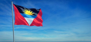 Antigua ve Barbuda 'nın ulusal bayrağı açık mavi gökyüzünün önünde rüzgarda dalgalanıyor.