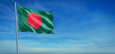 Bangladeş 'in ulusal bayrağı açık mavi gökyüzünün önünde rüzgarda dalgalanıyor.