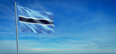 Botswana 'nın ulusal bayrağı açık mavi gökyüzünün önünde rüzgarda dalgalanıyor.