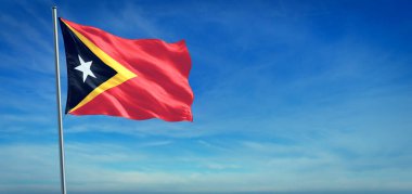 Doğu Timor 'un ulusal bayrağı açık mavi gökyüzünün önünde rüzgarda dalgalanıyor.